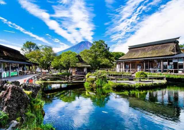 Visitors walking around the spring ponds and traditional houses at Oshino Hakkai on a Mount Fuji day trip from Tokyo